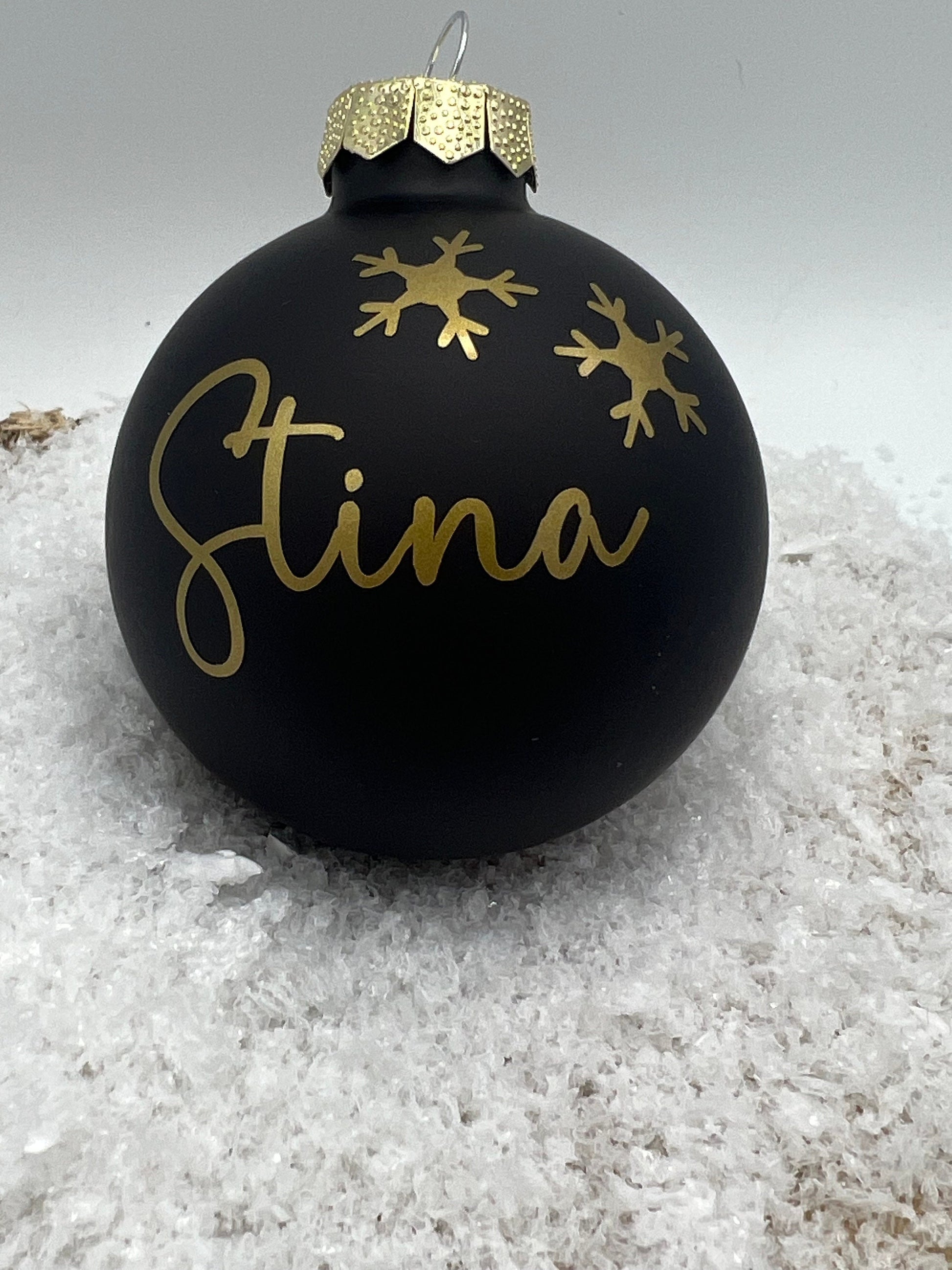 Schwarze personalisierte Weihnachtskugel mit goldenen Schneeflocken, ideal als Christbaumschmuck oder individuelles Weihnachtsgeschenk.