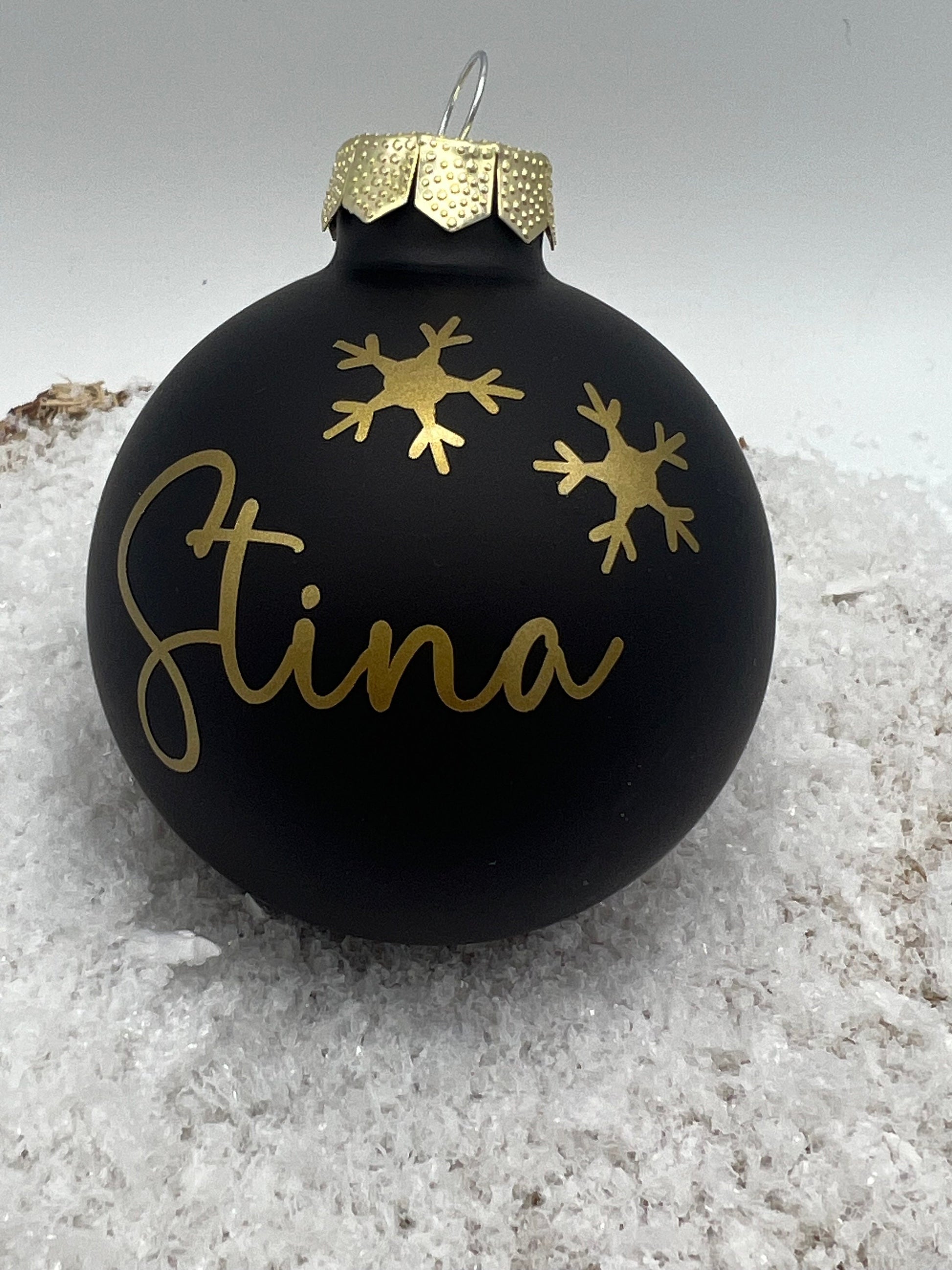 Schwarze personalisierte Weihnachtskugel mit goldenen Schneeflocken, ideal als Christbaumschmuck oder individuelles Weihnachtsgeschenk.